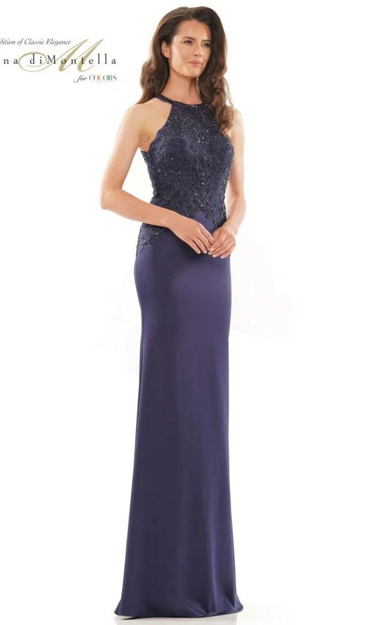 A woman wears the Rina Di Montella RD2755, a navy long formal dress featuring a sleeveless design, fitted silhouette, embroidered bodice, and intricate lace detailing.